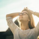 Woman smiling and lifting her face to the sunlight