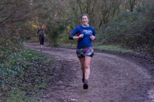 Photograph of Rachel Payne white woman smiling and running down a track